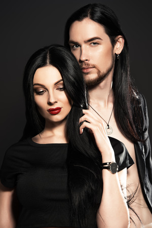 Beautiful gorgeous couple in elegant evening dresses. Fashion, glamour. Black background.の写真素材