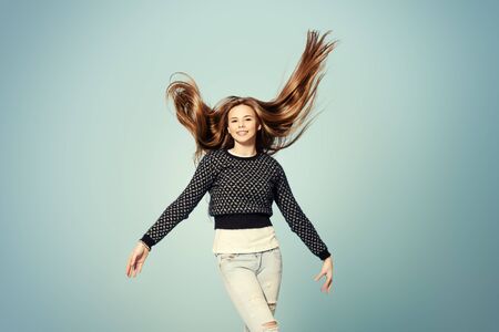 Joyful girl teenager waves a beautiful long hair.の写真素材