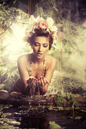 Beautiful slender woman in bikini among tropical plants. Beauty, fashion. Spa, healthcare. Tropical vacation.の写真素材