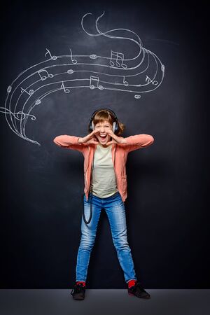 Expressive teen girl enjoys singing a song. Generation. Studio shot.の写真素材