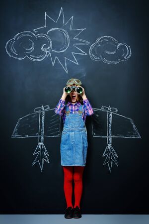 Dream flight. Cheerful girl imagines herself a pilot. Childhood. Fantasy, imagination.の写真素材