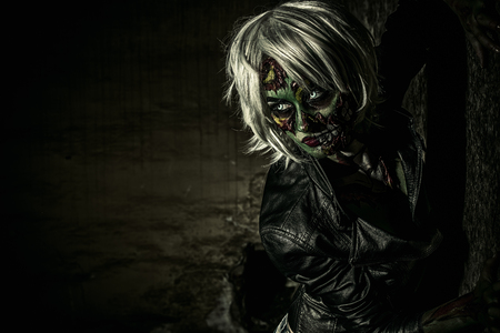 Terrible bloodthirsty zombie woman in the slums. Body-painting project. Glamorous zombie girl. Halloween make-up. Horror.の写真素材