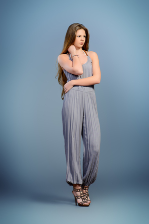 Fashion shot of a beautiful young model with shiny long hair. Healthy hair, haircare.Studio shot over grey background.の写真素材