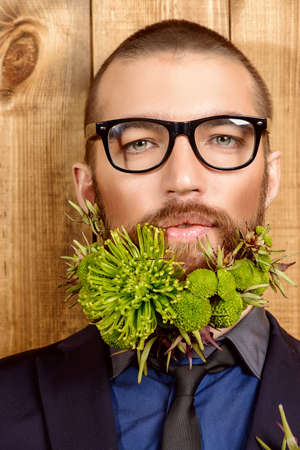 Handsome mature man with a beard of green flowers. Men's beauty. Barbershop.の写真素材