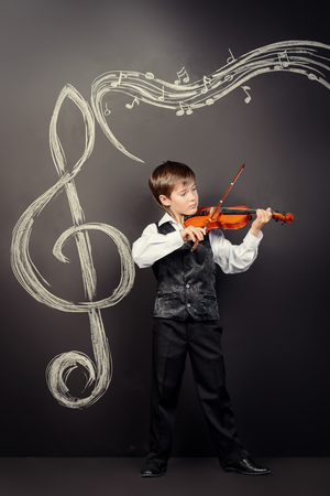 Freckled nine year old boy playing the violin. Musical education. Inspiration.の写真素材