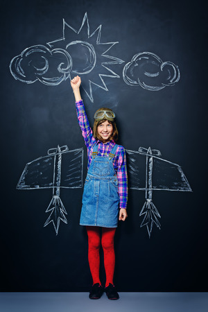 Dream flight. Cheerful girl imagines herself a pilot. Childhood. Fantasy, imagination.の写真素材