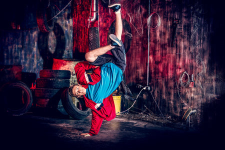 Trendy young man dancer dancing in the old garage.