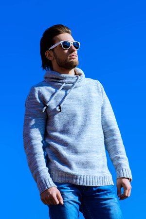 Young handsome man in casual clothes and sunglasses over blue sky.の写真素材
