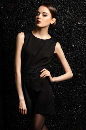 Vogue shot of a brunette young woman with magnificent brown eyes posing over black background.の写真素材