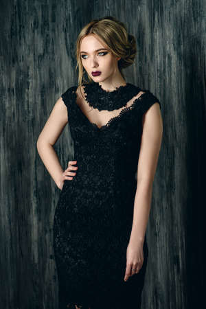 Vogue shot of a beautiful young woman with dark make-up wearing black evening dress.の写真素材