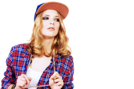 Modern teenager girl wearing casual clothes and a cap posing at studio. Teen generation. Youth fashion style. Isolated over white.の写真素材