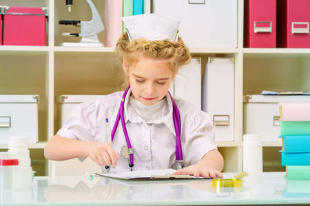 Pretty little girl playing a doctor at home. Different occupations. Children's Health, Pediatrics.の写真素材