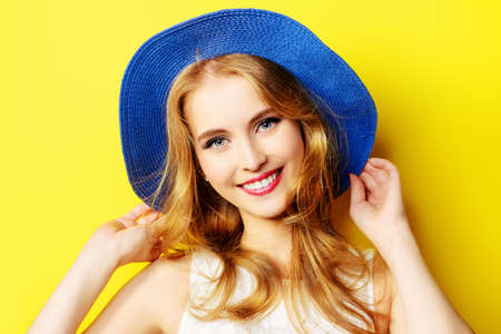 Portrait of a beautiful girl with a happy toothy smile over yellow sunny background. Summer holidays. Healthy teeth. Happiness.の写真素材