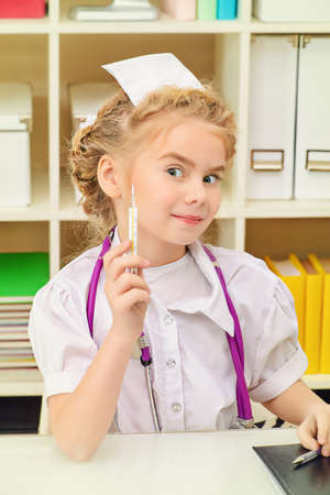 Pretty little girl playing a doctor at home. Different occupations. Children's Health, Pediatrics.の写真素材