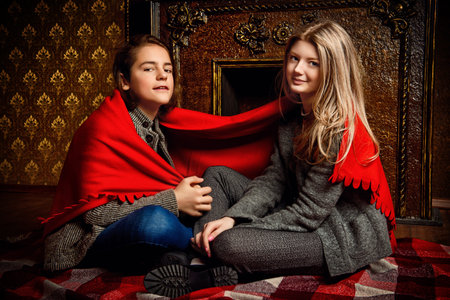 Two romantic young people spending evening together by the fireplace.の写真素材