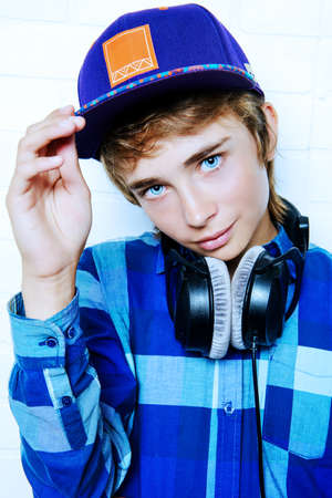 Modern teenage boy enjoys the music in headphones. Studio shot. Youth culture.の写真素材