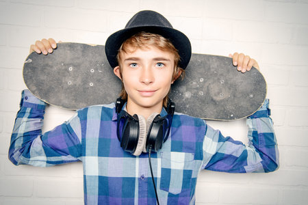 Modern teenage boy with skateboard. Studio shot. Youth culture.