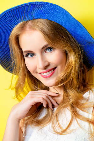 Portrait of a beautiful girl with a happy toothy smile over yellow sunny background. Summer holidays. Healthy teeth. Happiness.の写真素材