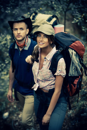 Hiking couple. Young people makes a hike in the woods. Active lifestyle, tourism. Tourist equipment.
