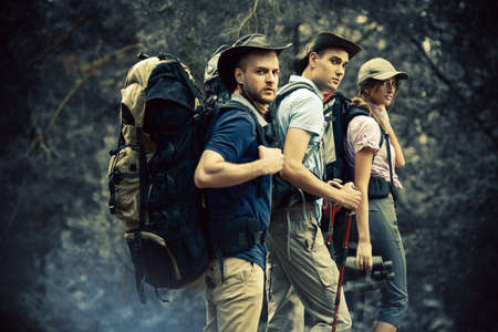 Adventure and hiking. Group of young people make a hike in mountains. Active lifestyle. Tourist equipment.の写真素材