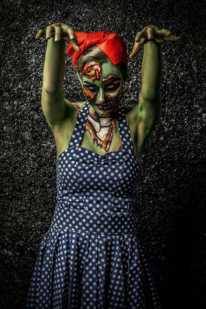 Frightening pin-up zombie girl over dark background.  Body-painting project. Halloween make-up. Horror.の写真素材