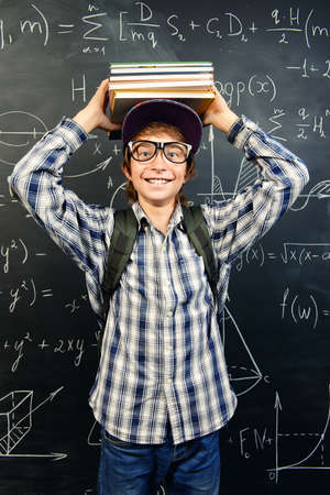 Education, high school, college. Portrait of a student boy standing by a school blackboard.の写真素材