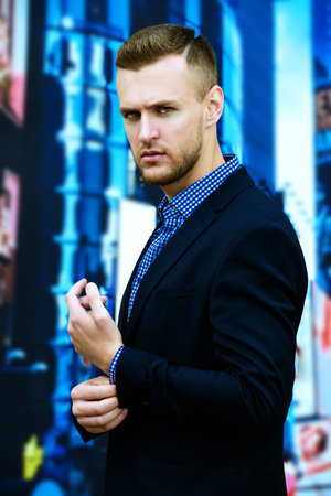 Respectable young man in a suit in the center of a big city. Fashion shot. Business style.