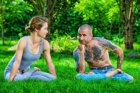 Man and woman yogi doing various yoga poses in a pair. Healthy yoga lifestyle. Yoga in the summer park, outdoor.の写真素材