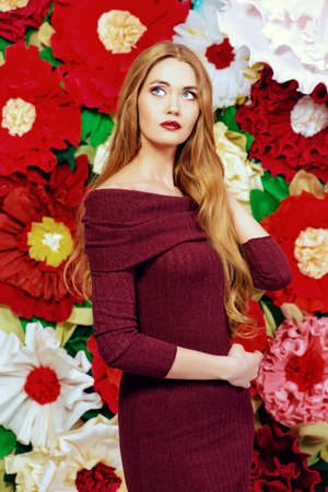Portrait of a beautiful happy woman posing on a background of bright large flowers. Beauty, fashion. Summer inspiration.の写真素材