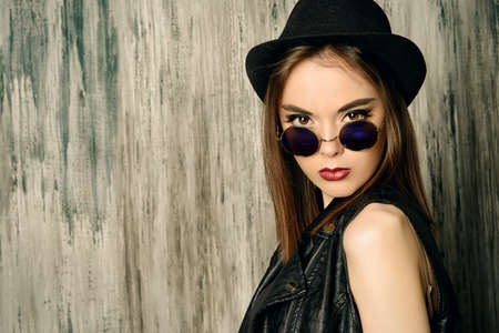 Fashion shot of a modern brunette girl with beautiful big brown eyes wearing black leather jacket. Beauty, fashion. Youth generation.の写真素材