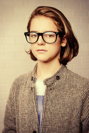 Portrait of a serious twelve year old boy wearing glasses. Boy teenager. Education.の写真素材