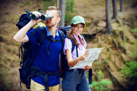 Hiking couple. Young people makes a hike in the woods. Active lifestyle, tourism. Tourist equipment.