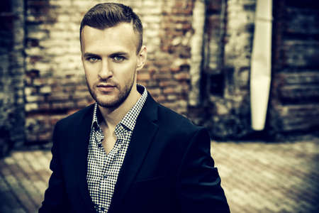 Handsome elegant man in a suit walking down the city street. Fashion shot. Business man outdoor.の写真素材