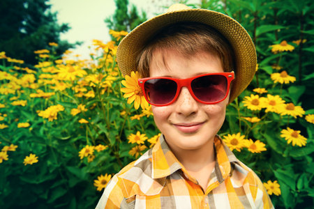Happy summer boy in sunglasses and straw hat at a park on a sunny day. Happy childhood. Holidays.の写真素材