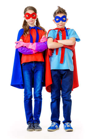 Boy and girl teenagers in a costume of superheroes posing together. Isolated over white background.の写真素材