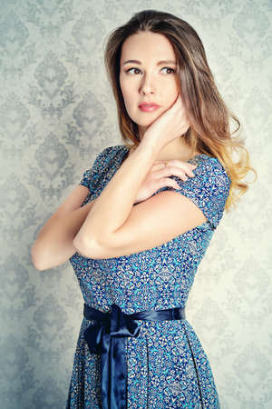 Portrait of a beautiful young woman in  elegant evening dress by a vintage wall.の写真素材