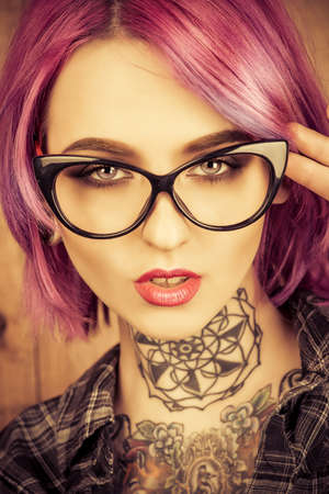 Cool girl with bright crimson hair and tattoo on her body. Modern generation. Optics style.の写真素材
