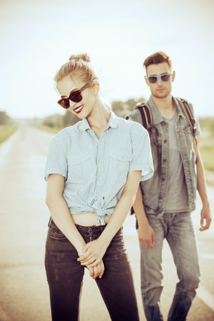 Fashionable models wearing jeans clothes posing on a highway. Denim style. Sepia, retro styled.