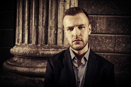 Respectable well-dressed man on a city street. Old town. Fashion shot. Business man outdoor. Sepia.の写真素材