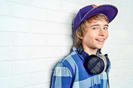 Modern teenage boy enjoys the music in headphones. Studio shot. Youth culture.の写真素材