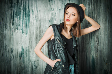 Fashion shot of a modern brunette girl with beautiful big brown eyes wearing jeans and black leather...