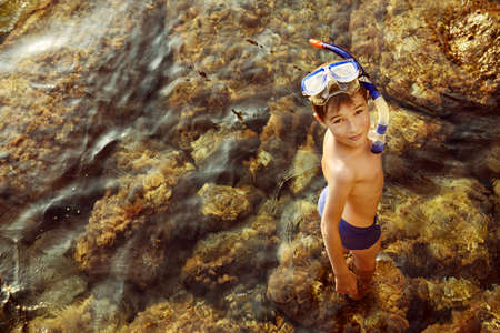 Happy boy enjoys summer holidays at the seaside. A boy swims in the sea snorkelling. Happy childhood.の写真素材