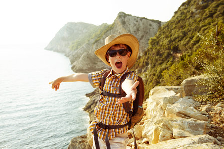 Happy boy spends the summer holidays at the seaside. Outdoor activities, tourism and adventure.