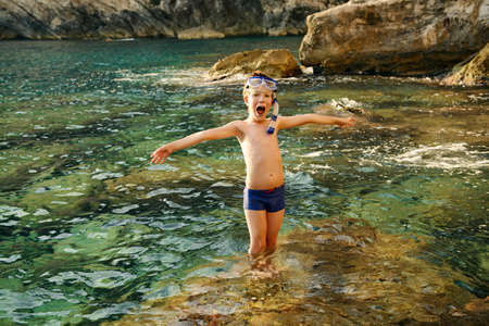 Happy boy enjoys summer holidays at the seaside. A boy swims in the sea snorkelling. Happy childhood.の写真素材