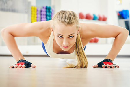 Active athletic young woman doing push-ups. Healthy lifestyle. Fitness, aerobics, bodybuilding.