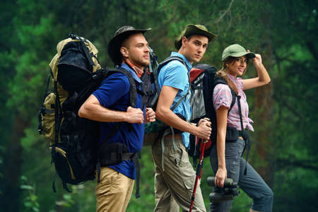 Adventure and hiking. Group of young people make a hike in mountains. Active lifestyle. Tourist equipment.の写真素材
