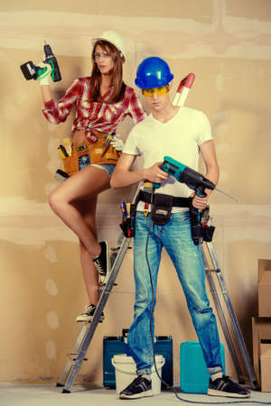 Male and female construction workers. Smiling young couple in love is going to renovate their new apartment.の写真素材