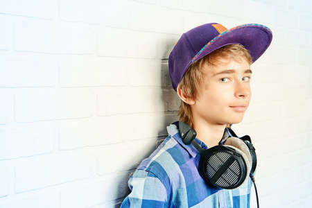 Modern teenage boy enjoys the music in headphones. Studio shot. Youth culture.の写真素材