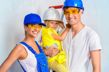 Young family with a kid moving into a new home and is preparing to repair apartments. Repair, construction and mortgage concept.の写真素材