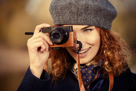 Autumn style. Beautiful smiling woman with bright foxy hair wearing beret and black coat photographs. Beauty, fashion.の写真素材